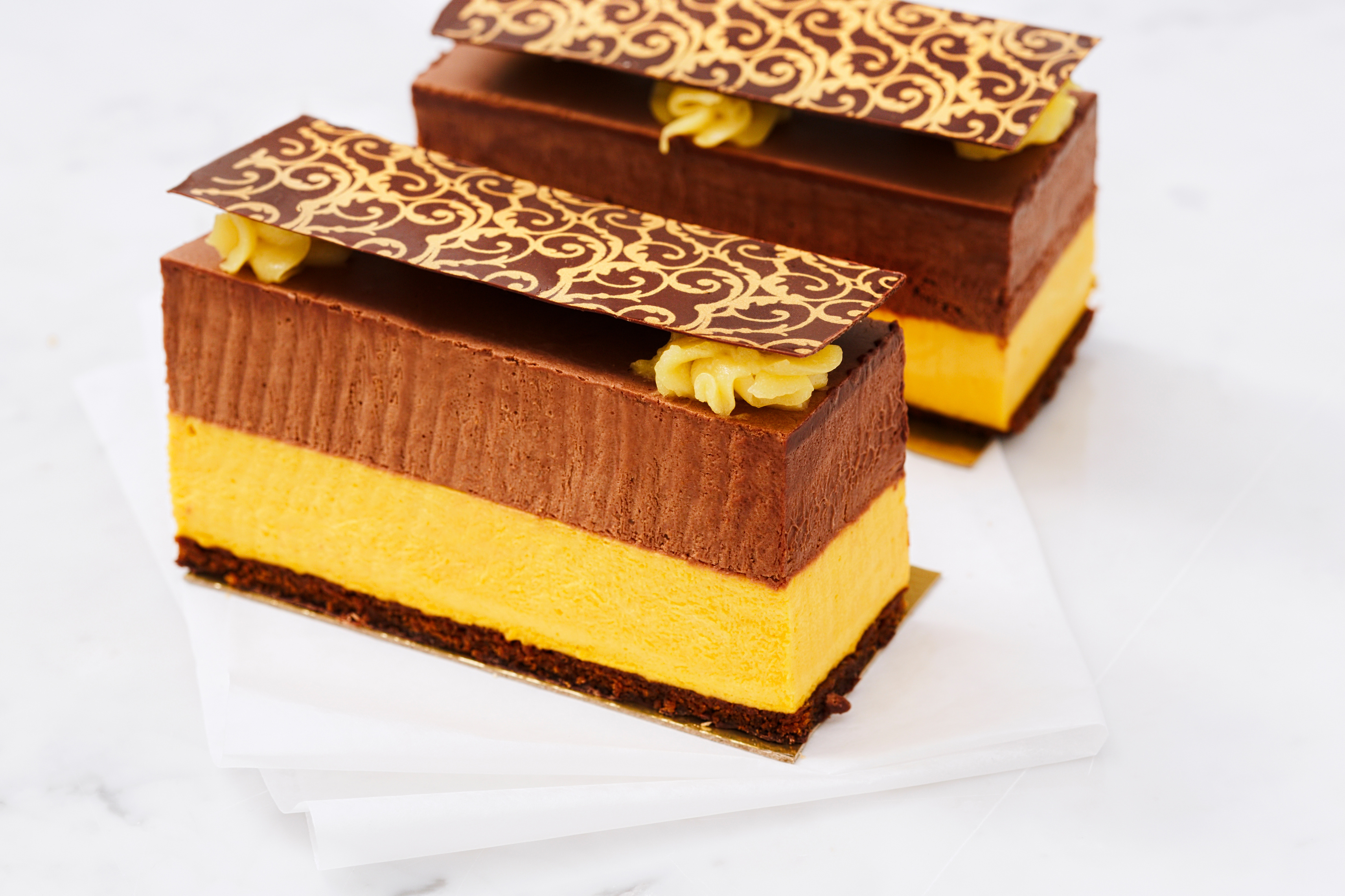 Sponge cake with chocolate and mango mousse. Horizontal shot